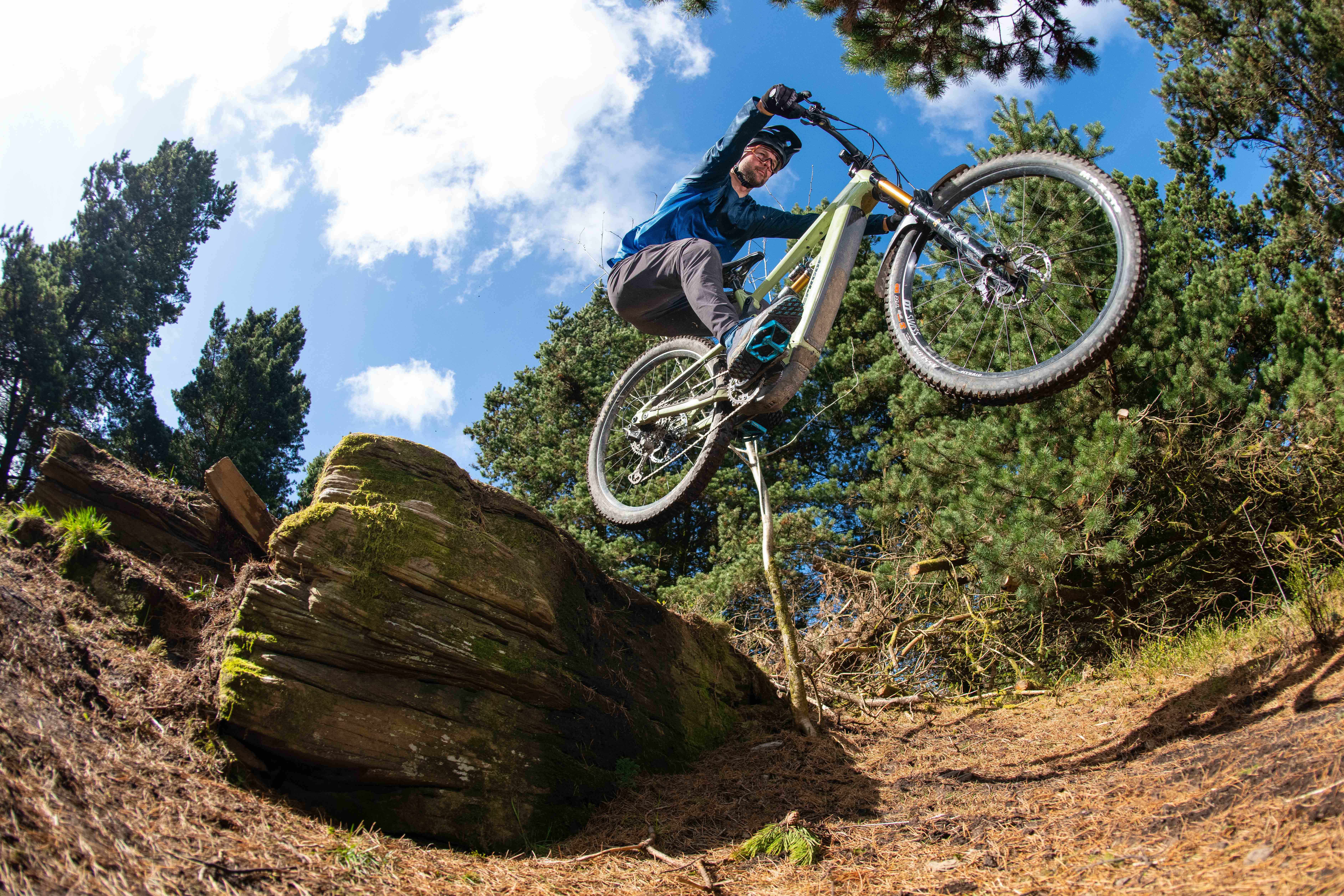 Alex Evans riding an electric mountain bike off a drop at Bike Park Wales