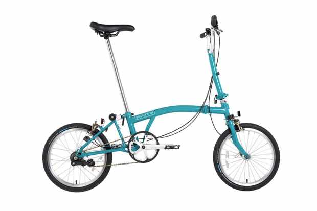 A photography of a light blue Brompton folding bicycle on a white background